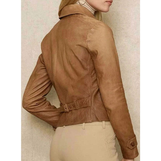 A woman shown from the back wearing a cropped tan leather jacket with a belted waist and beige pants, against a light textured wall.