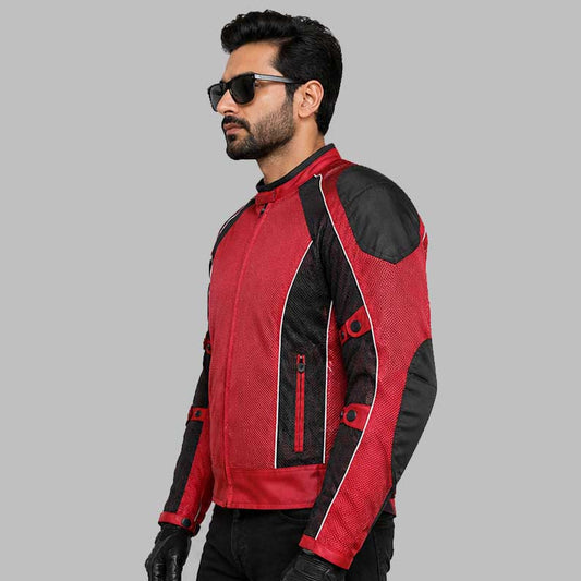 A man wearing a red and black motorcycle jacket with black sunglasses, standing against a solid gray background.