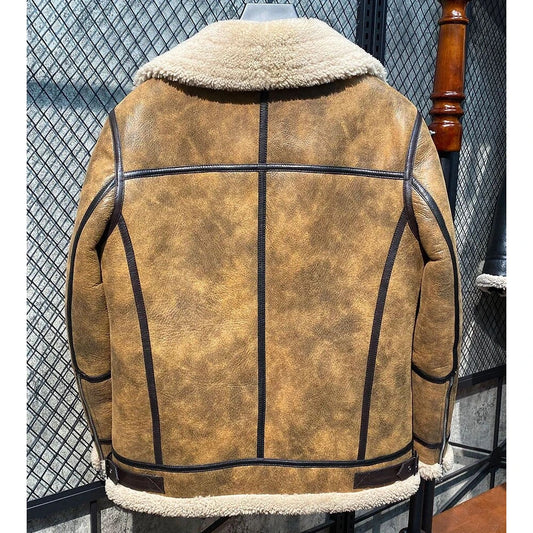A brown distressed leather jacket with a cream-colored shearling lining, shown from the back on a hanger against a chain-link fence background.