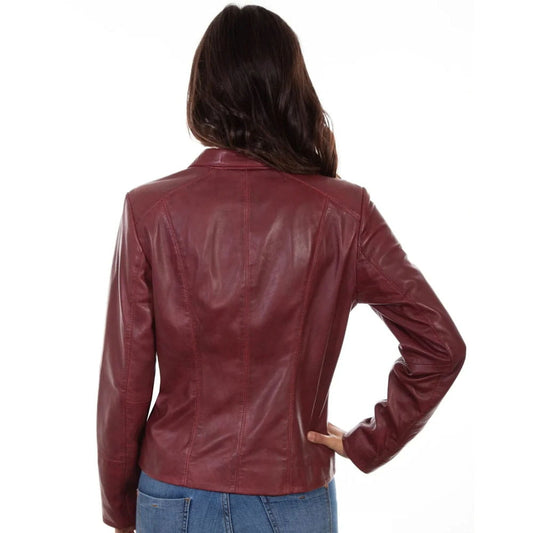 A woman viewed from the back wearing a fitted burgundy leather jacket and blue jeans against a plain white studio background.