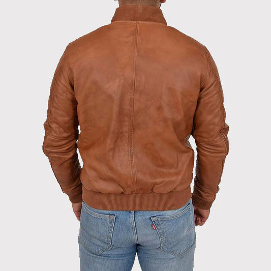 A man viewed from the back wearing a brown leather bomber jacket and light blue jeans, set against a plain light gray background.
