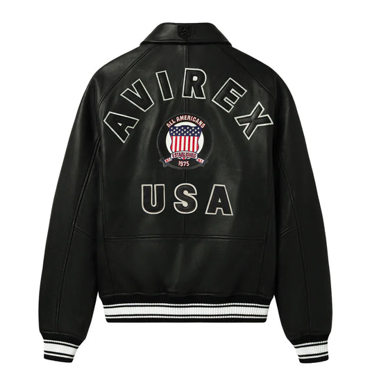 Black leather varsity jacket shown from the back, featuring 'AVIREX USA' embroidered in white outlined lettering with an American flag crest in the center, and white and black striped ribbed cuffs and hem.