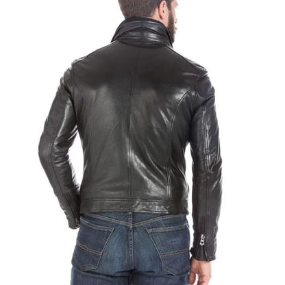 A man viewed from the back wearing a black leather jacket and blue jeans against a plain white background.