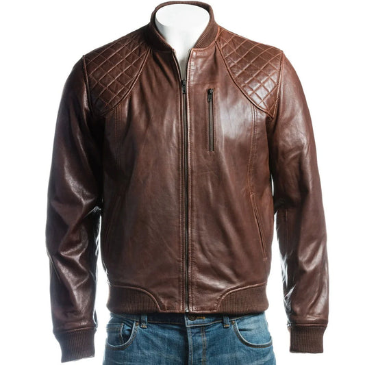 A brown leather jacket with quilted shoulder panels and a front zipper, displayed on a white mannequin torso with blue jeans visible at the bottom against a plain white background.