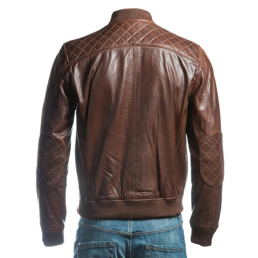 A brown leather jacket with quilted diamond-patterned panels on the shoulders and elbows, shown from the back on a model wearing blue jeans against a white background.
