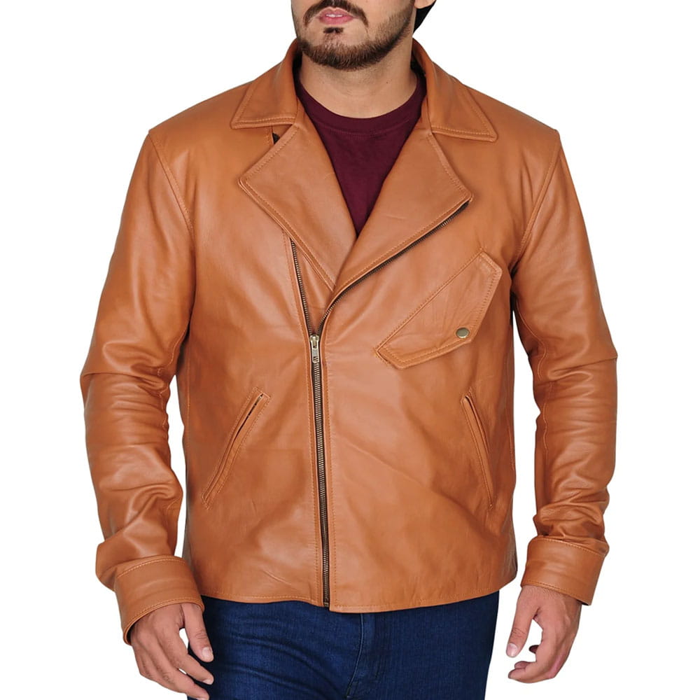 A man wearing a tan leather motorcycle jacket over a dark maroon t-shirt and blue jeans, shown from the chin down against a plain white background.