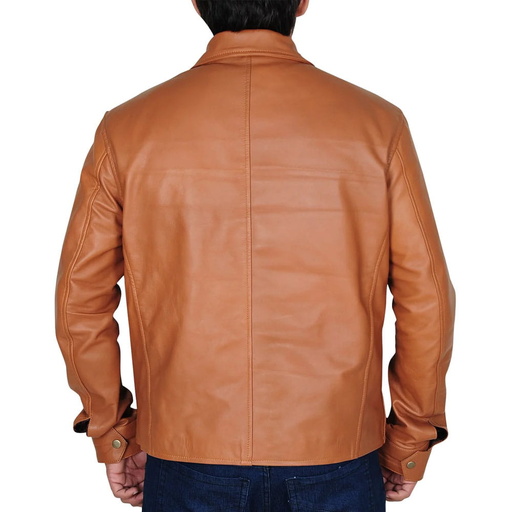 A man viewed from the back wearing a tan leather jacket and dark blue jeans against a plain white background.