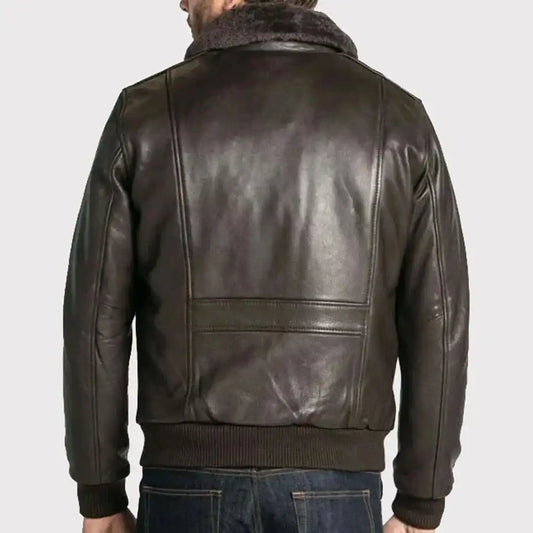 A man viewed from the back wearing a dark brown leather jacket with a fuzzy collar and ribbed knit trim, paired with blue jeans, against a light gray background.