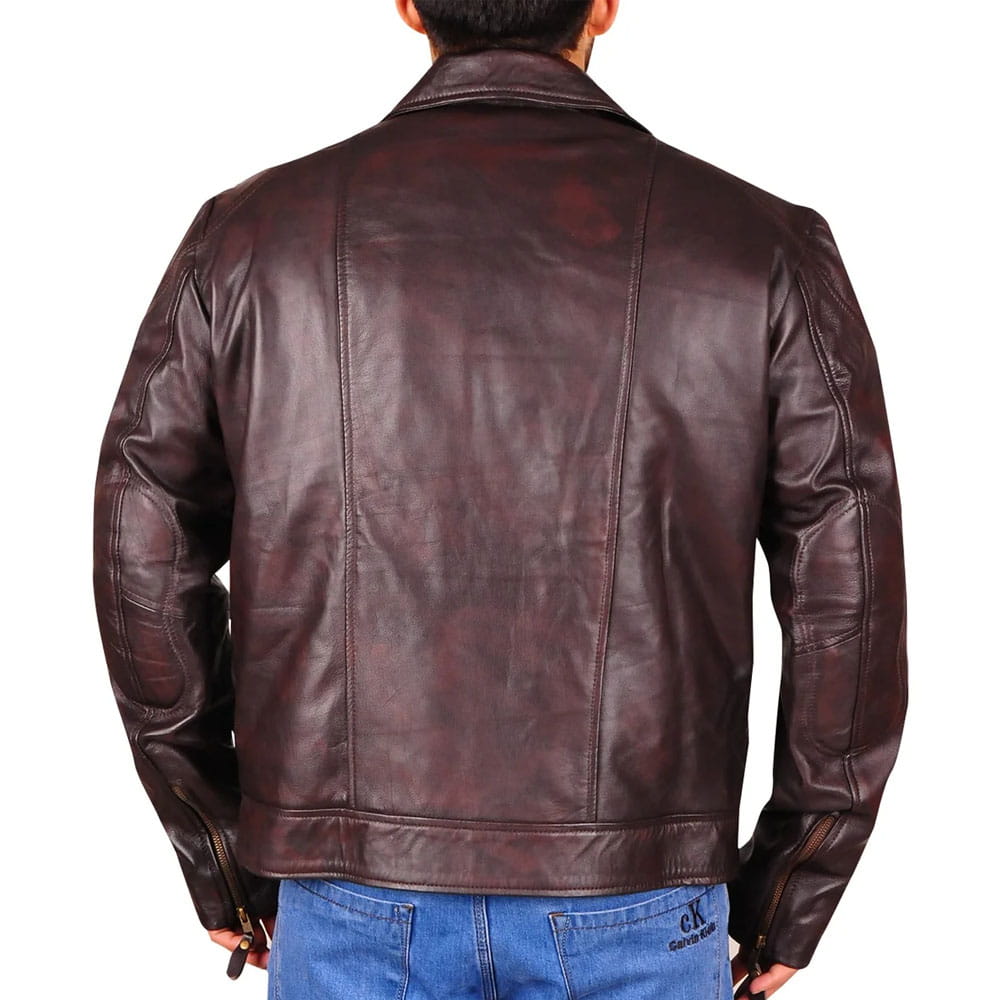 A man viewed from the back wearing a dark brown leather jacket and blue jeans against a plain white background.