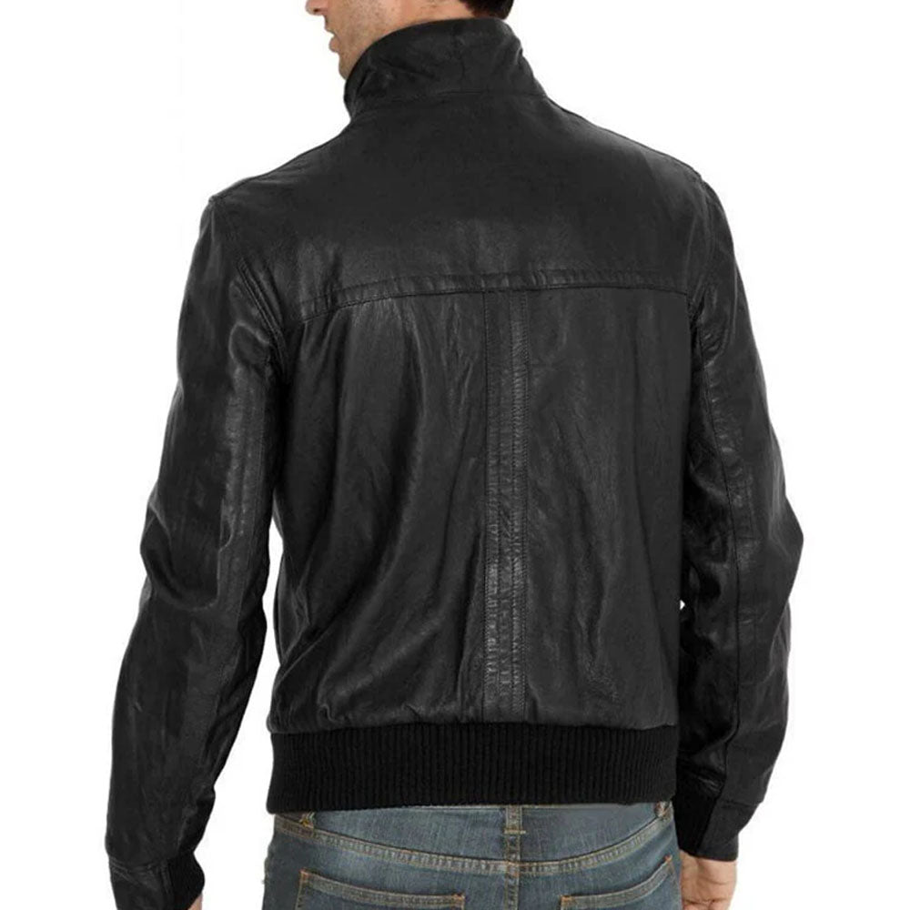 A man wearing a black leather jacket, shown from the back. The jacket features a high stand-up collar, a ribbed knit hem and cuffs, and a vertical seam down the center back.
