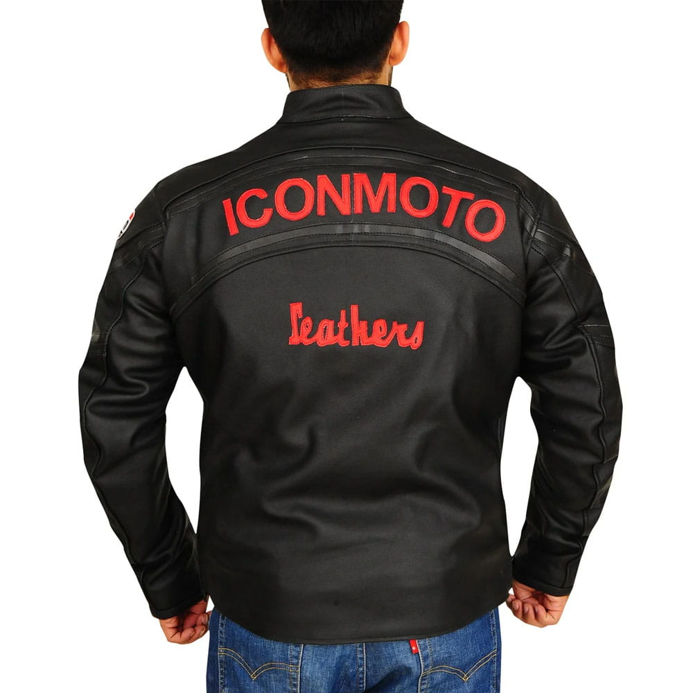 A man viewed from the back wearing a black leather jacket with 'ICONMOTO' and 'Leathers' embroidered in red on the back, paired with blue jeans against a white background.