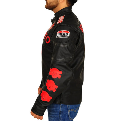 A man wearing a black leather motorcycle jacket with red graphic patches and an 'ICON' logo on the shoulder, paired with blue jeans against a white background.