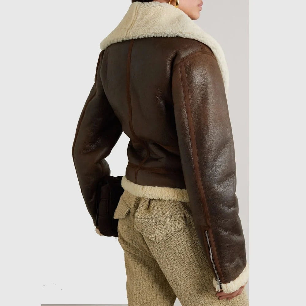 Brown leather jacket with white fur lining worn by a person on a plain background