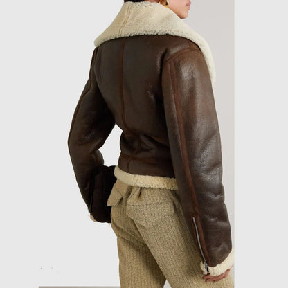 Brown leather jacket with white fur lining worn by a person on a plain background
