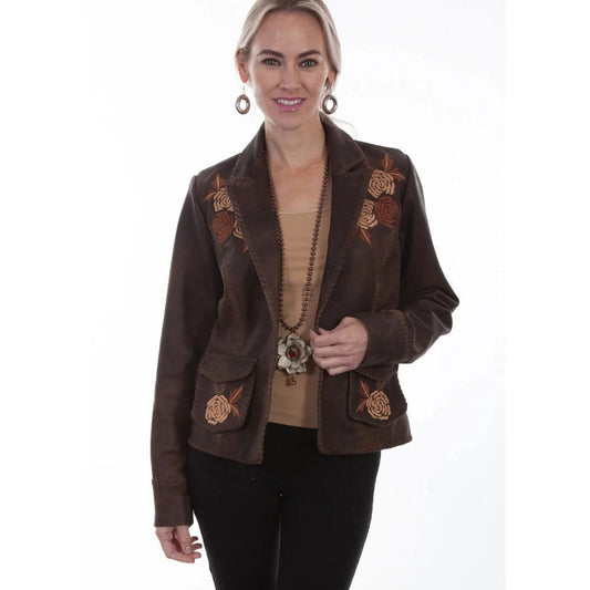 A woman modeling a brown suede western-style blazer with embroidered floral details on the shoulders and pockets, worn over a tan top and black pants against a white background.