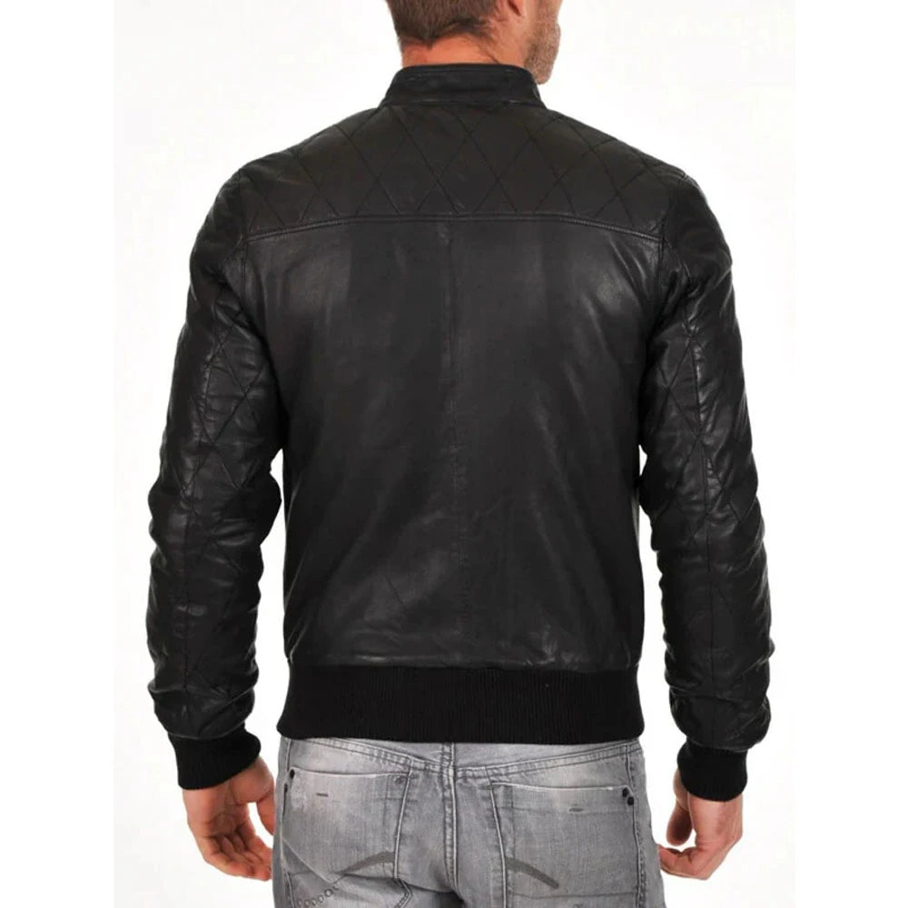 A man viewed from the back wearing a black leather jacket with quilted shoulder panels and ribbed knit collar, cuffs, and hem, paired with light gray jeans against a plain white background.