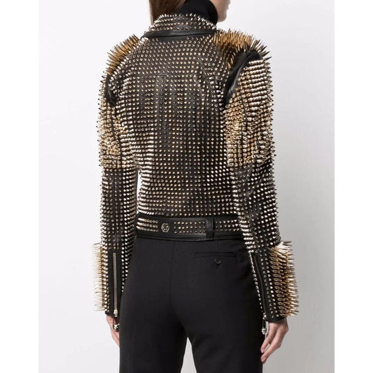 A model shown from the back wearing a black studded leather jacket with gold-toned spiked detailing on the shoulders and sleeves, paired with black trousers.
