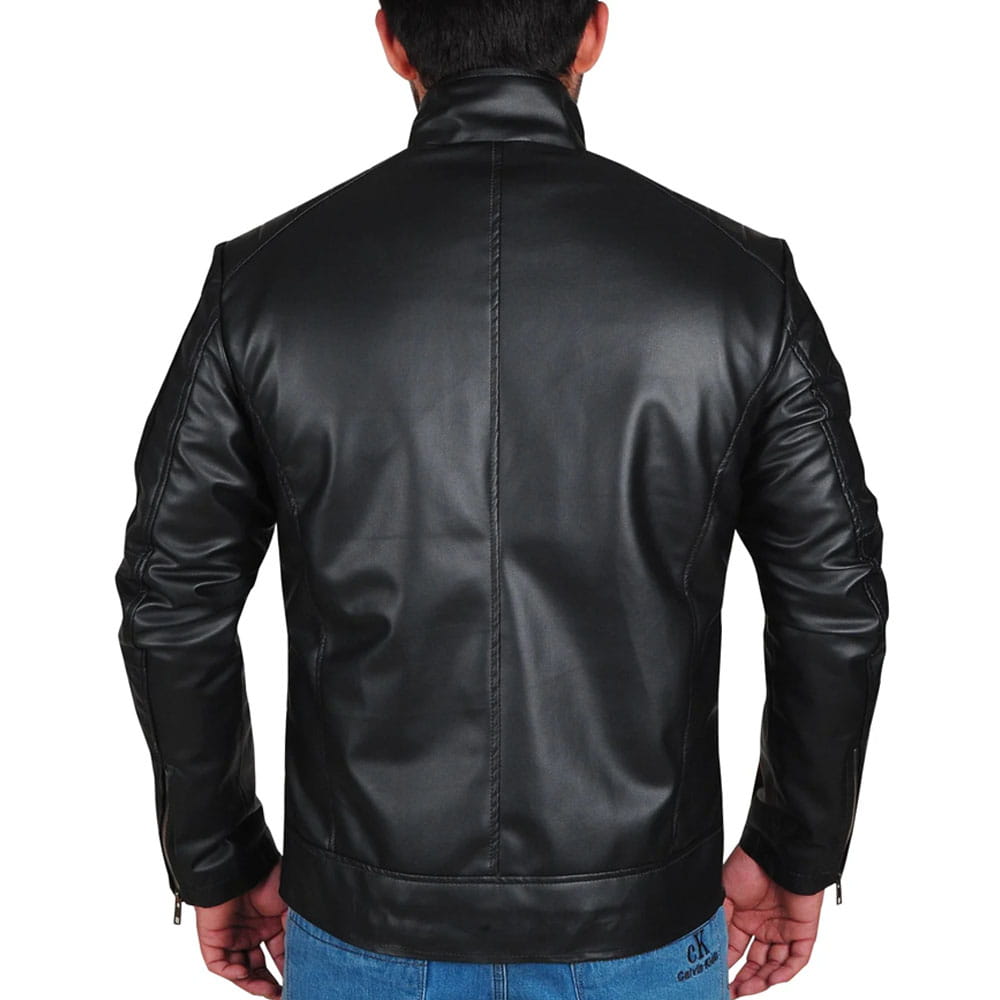 A man viewed from the back wearing a black faux-leather biker jacket, paired with blue jeans, against a plain white background.