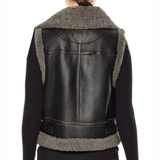 Black faux leather vest with gray shearling lining on the collar, sides, and hem, shown from the back on a model wearing a black long-sleeve shirt.