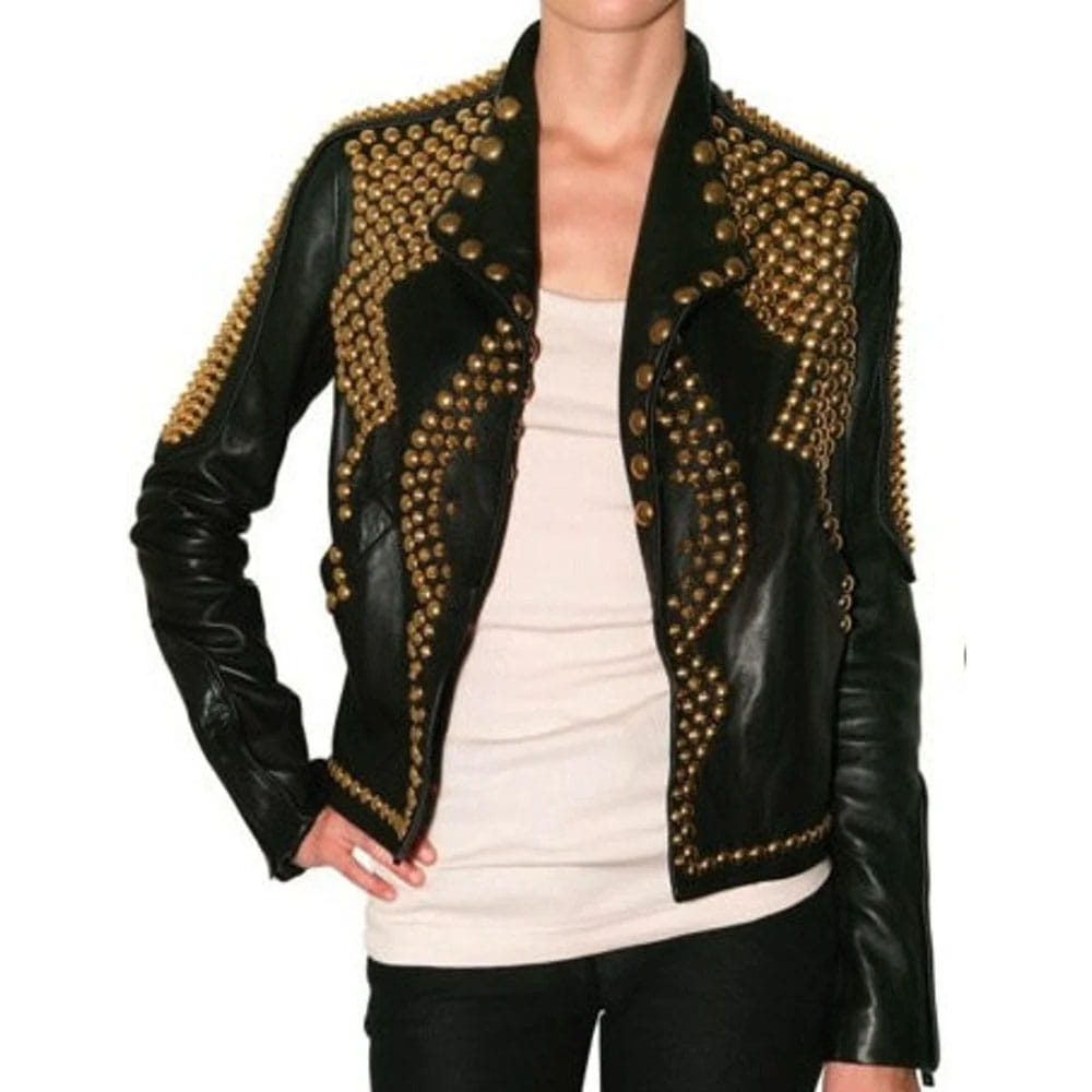 A black leather jacket heavily embellished with gold-tone studs and decorative studs, worn by a model over a cream-colored top and black pants against a white background.