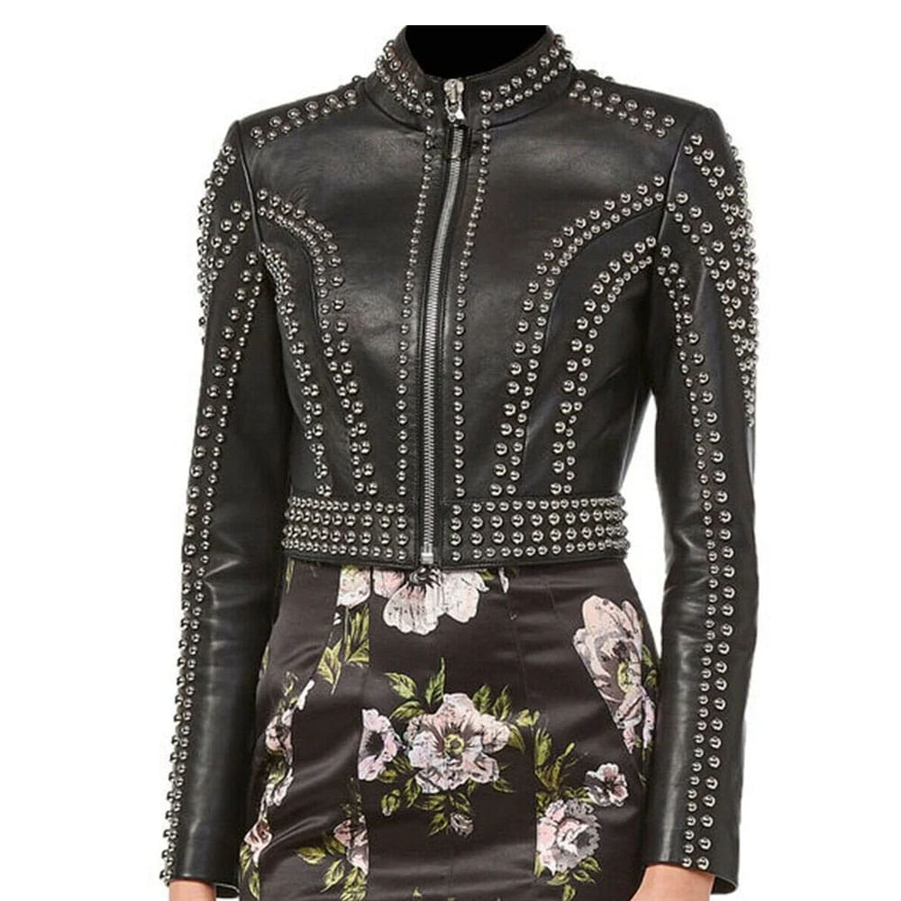 A black leather jacket with silver studded embellishments, featuring a high collar, front zipper, and a matching floral-print skirt.