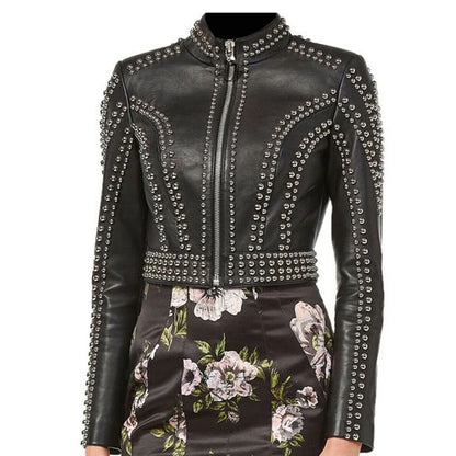 A black leather jacket with silver studded embellishments, featuring a high collar, front zipper, and a matching floral-print skirt.