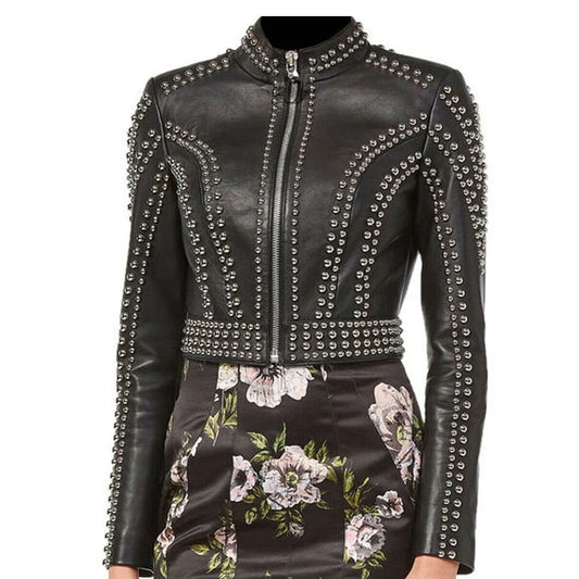 A black leather jacket with silver studded embellishments, featuring a high collar, front zipper, and a matching floral-print skirt.