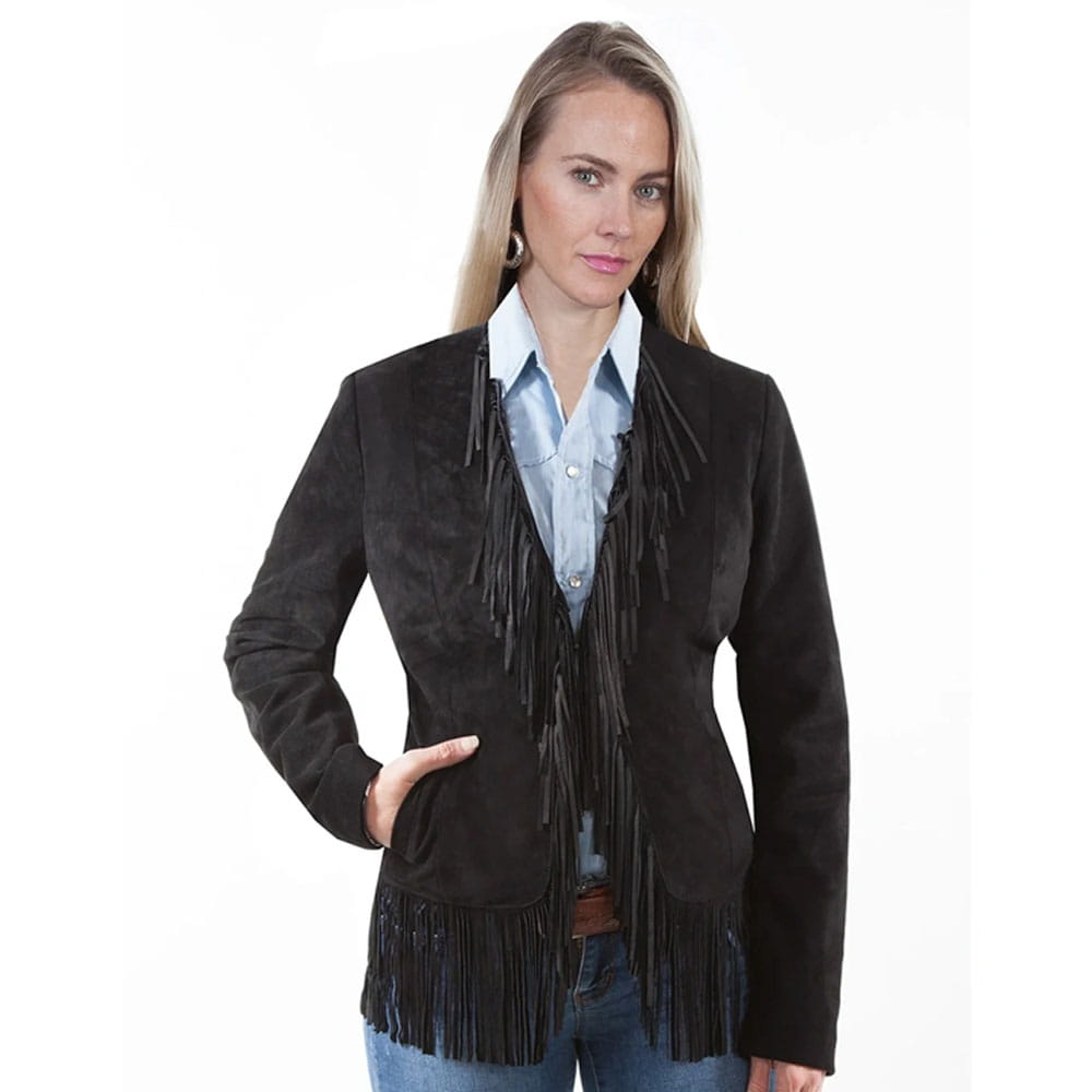A woman modeling a black suede fringe jacket over a light blue button-down shirt and jeans, photographed against a plain white studio background.