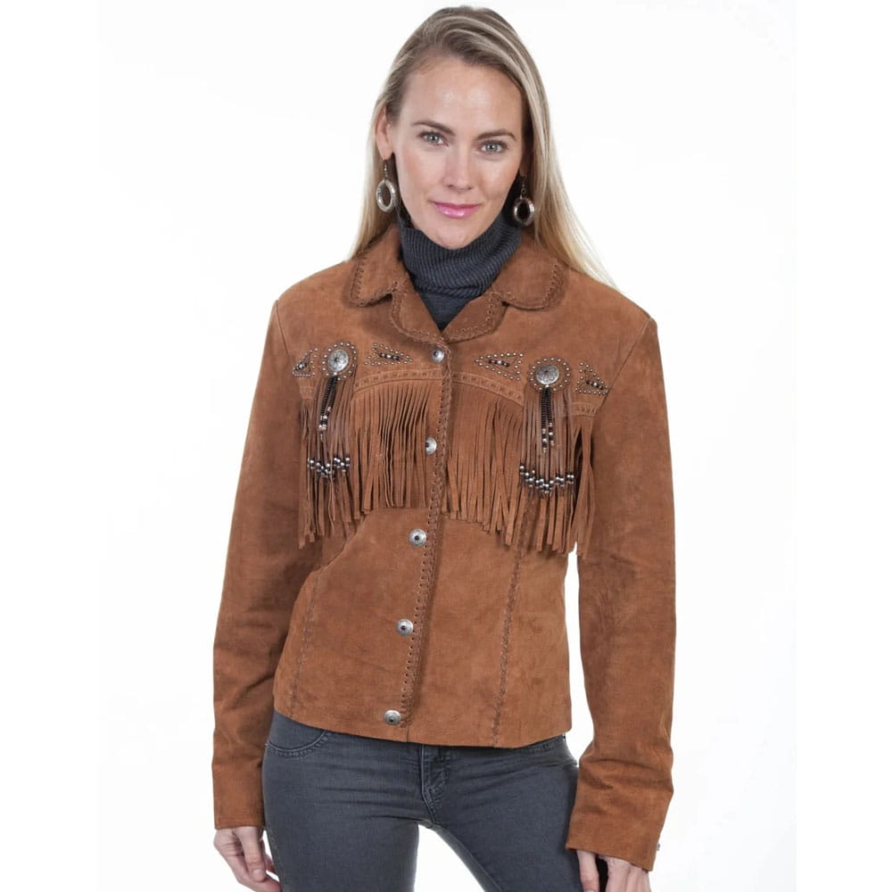 A woman modeling a brown suede western-style jacket with fringe and silver-tone decorative embellishments, paired with dark gray jeans against a plain white background.