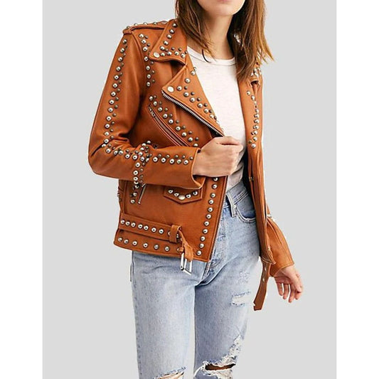 A woman wearing a brown studded moto jacket over a white top and light blue ripped jeans, shown from the neck down against a light gray background.