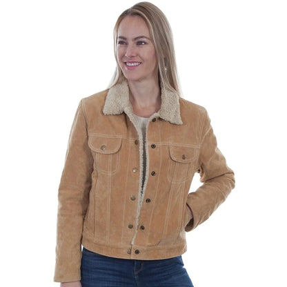 A woman wearing a tan suede jacket with a cream sherpa collar, paired with a white top and blue jeans, photographed against a solid white background.