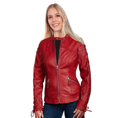A woman wearing a red faux leather motorcycle jacket with lace-up details on the sleeves, styled over a black top and blue jeans, set against a plain white background.