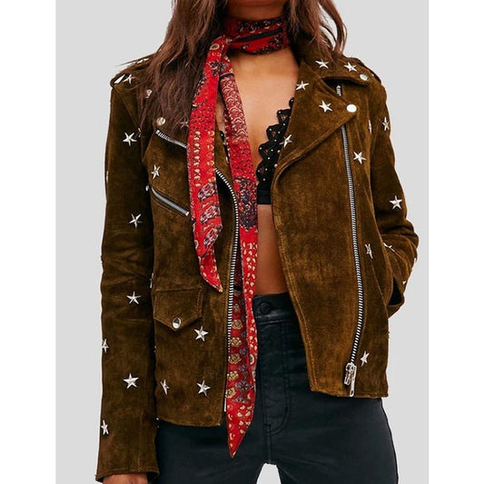 A woman wearing a brown suede moto jacket with silver star embellishments, styled with a red patterned bandana scarf and black pants against a light gray background.