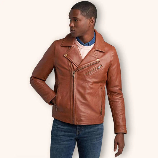 A man wearing a brown leather motorcycle jacket over a white t-shirt and blue jeans, photographed against a solid off-white background.