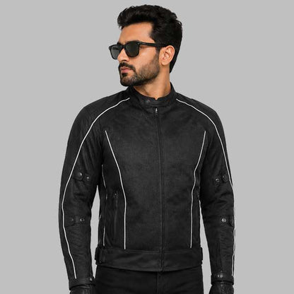 A man wearing a black motorcycle jacket with white contrast stitching, black sunglasses, and black gloves, posed against a solid gray background.