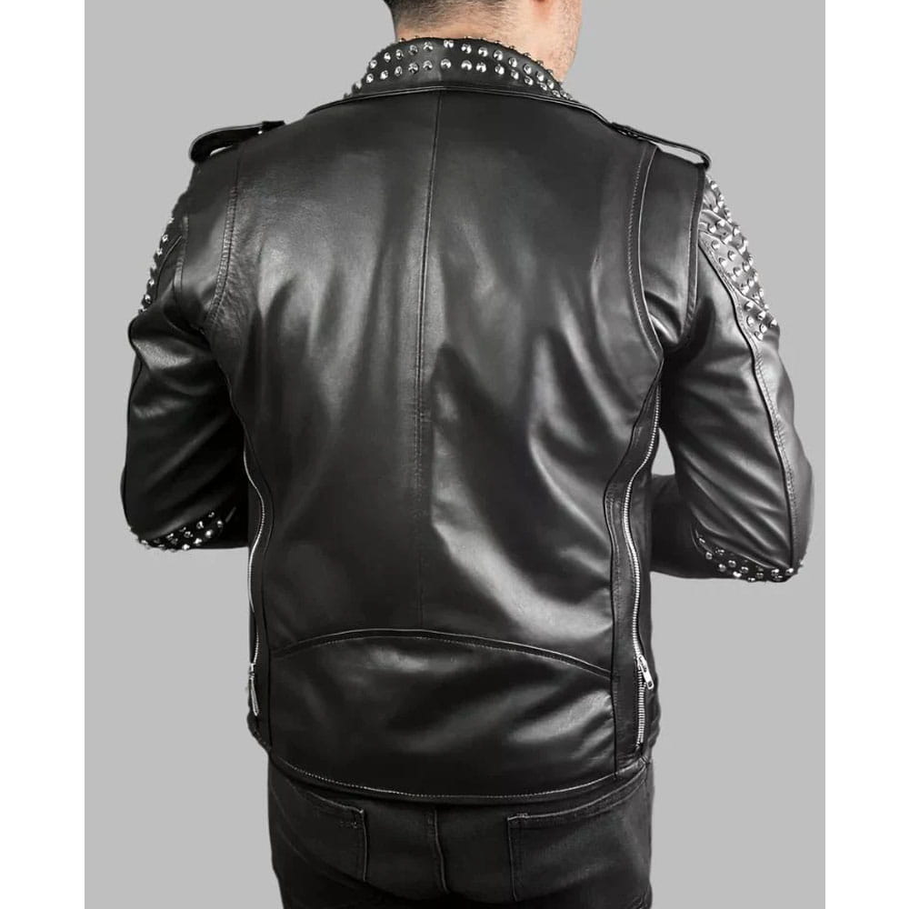 A man viewed from the back wearing a black leather jacket with silver studded detailing on the collar and shoulders, set against a solid gray background.