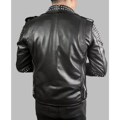 A man viewed from the back wearing a black leather jacket with silver studded detailing on the collar and shoulders, set against a solid gray background.