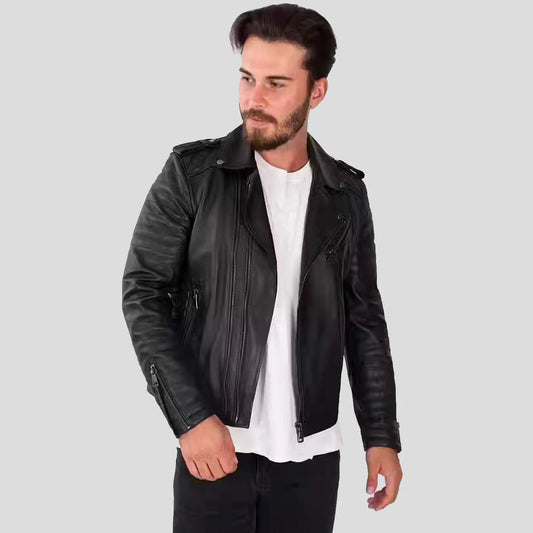 Man wearing a black leather jacket over a white shirt on a light gray background