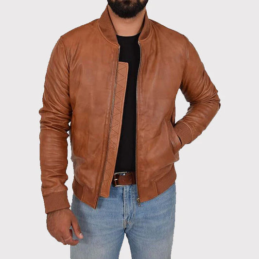 A man wearing a brown leather bomber jacket over a black t-shirt and blue jeans, shown from the chin down against a light gray background.